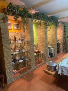 Cette chambre dispose d'une cuisine avec une table et un mur. dans l'établissement Villa Bimba, alojamiento con piscina y barbacoa, à Caldas de Reis