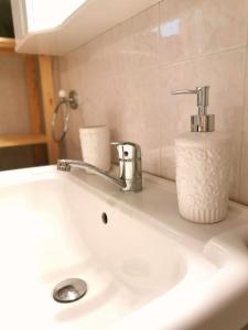 雅典的住宿－Lucy's apartment，浴室水槽配有水龙头和一卷卫生纸