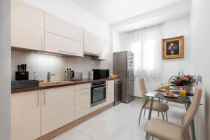 a kitchen with white cabinets and a table and chairs at Budapest Deluxe Apartman with free parking place in Budapest