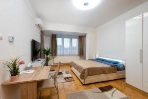a bedroom with a bed and a desk and a table at Budapest Deluxe Apartman with free parking place in Budapest