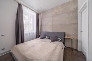 een slaapkamer met een bed en een groot raam bij Lovely 1-bedroom apartment with a free parking in Jūrmala