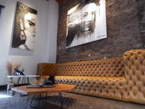 a brown leather couch in a room with a table at Hotel Tila in Cholula