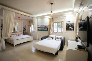 a bedroom with two beds and a tv in it at Villa Magnolia in Manot in Manot