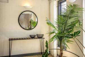 a mirror on a wall next to a table with a plant at Exquisite, Artsy ArtepHouse in Cape Town