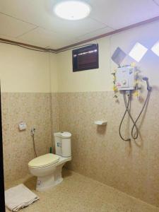 a bathroom with a toilet and a shower at The Sunrise Beach Cafe and Guesthouse in Ban Tha Khoi