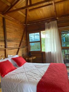 a bedroom with a bed in a log cabin at CABAÑA LOS NOGALES in San Agustín +220 photos