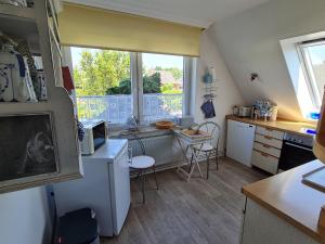 een kleine keuken met een tafel en een raam bij Apartment Seaside in Husum