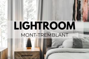 a bedroom with a bed and a nightstand next to a window at Le Lightroom by Gestion ELITE in Mont-Tremblant