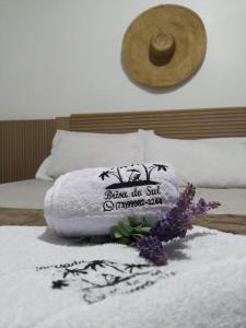 Una toalla sobre una cama con flores en Pousada Brisa do Sul, en Santa Cruz Cabrália