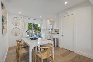 cocina blanca con mesa blanca y sillas en Chic and Comfy Home in the Heart of Silicon Valley, en Mountain View