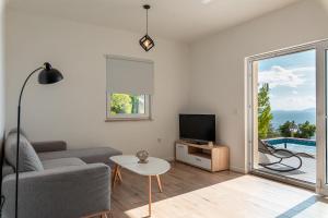 a living room with a couch and a tv and a table at Korkyra Seashell in Blato