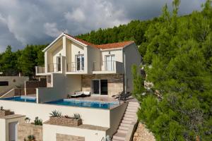 une villa avec une piscine et une maison dans l'établissement Korkyra Seashell, à Blato