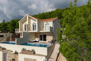 a villa with a swimming pool and a house at Korkyra Seashell in Blato