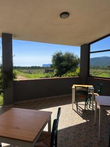 a room with tables and chairs and a large window at Agriturismo Graziano e Barbara in Porto Conte