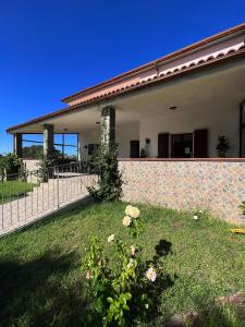 a house with a fence and a yard with flowers at Agriturismo Graziano e Barbara in Porto Conte