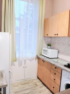 eine Küche mit einer weißen Mikrowelle und einem Fenster in der Unterkunft Apartment near the train station in Lwiw