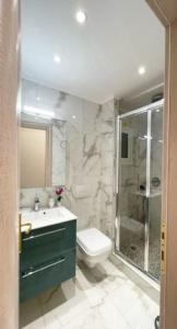 uma casa de banho com um lavatório, um WC e um chuveiro em Crimson Suite: 1-bedroom apartment in Thessaloniki em Tessalônica