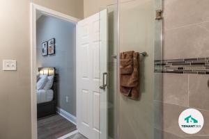 baño con ducha y puerta de cristal en Baltimore's Best Home Away From Home apts, en Baltimore