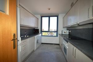 a large kitchen with white cabinets and a window at Lets Holidays Apartment Sea Views in Barcelona in Barcelona
