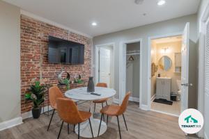 ein Esszimmer mit einer Ziegelwand, einem Tisch und Stühlen in der Unterkunft Baltimore's Best Home Away From Home apts in Baltimore