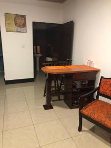 Apartments Pura Vida في ألاخويلا: طاولة خشبية وكرسي في الغرفة