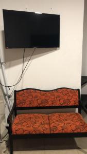 a bench with a flat screen tv on a wall at Apartments Pura Vida in Alajuela City