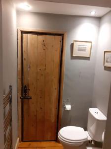 a bathroom with a toilet and a wooden door at Characterful Cottage near the Sea, Beach, Pier & Shops in Weston-super-Mare