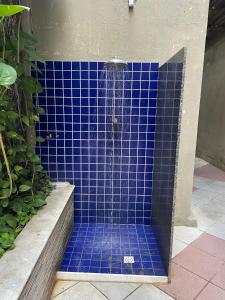 La salle de bains est pourvue d'une douche carrelée de bleu et de carrelage bleu. dans l'établissement HOTEL NAVEGANTES VISTA PARA MAR Boa Viagem, à Récife