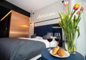 ein Hotelzimmer mit einem Bett und zwei Gläsern Wein in der Unterkunft Czarna Góra Biała Perła EnergyApart in Heudorf