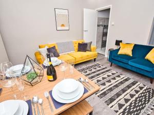 a living room with a yellow couch and a table at *Sleeps 9* Modern, 4 Bed House, Birmingham in Birmingham