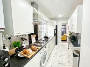 a white kitchen with a stove and a dishwasher at *Sleeps 9* Modern, 4 Bed House, Birmingham in Birmingham