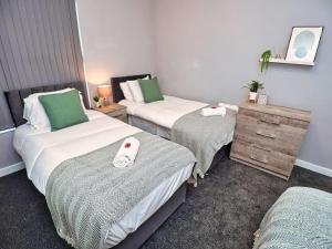 a hotel room with two beds and a dresser at *Sleeps 9* Modern, 4 Bed House, Birmingham in Birmingham