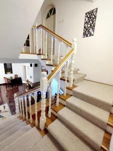 - un escalier dans une maison dotée de murs blancs et de parquet dans l'établissement Pensiune Forest Park, à Baia Mare