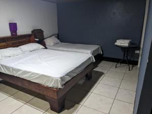 two twin beds in a room with a table at Apartments Pura Vida in Alajuela City