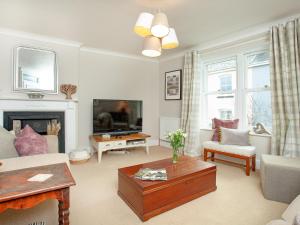 a living room with a couch and a tv at Upper Forge in Malborough