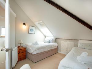 a attic bedroom with two beds and a window at Upper Forge in Malborough