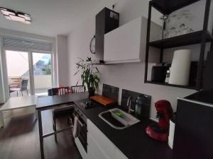 una cocina con encimera negra y fregadero en Apartment Voria, en Hamm