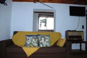 ein Sofa mit zwei Kissen darauf im Wohnzimmer in der Unterkunft Superb Bruzende Village in Baião