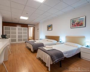 een kamer met 2 bedden en een wastafel bij Suites Rooms Valencia in Valencia