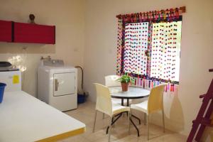 a kitchen with a table and chairs and a window at Hostal Casa Bohemia in Mérida