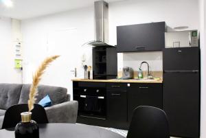kuchnia z czarną lodówką i stołem w obiekcie Idéal couples & pro - Proche centre ville et gare - Promenade au bord de la Charente - Parking à proximité - Wifi très haut debit - Équipement premium -Netflix w mieście Angoulême +7 zdjęć