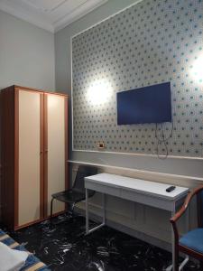 een wachtkamer met een tafel en een tv aan de muur bij Hotel Milazzo Roma in Rome