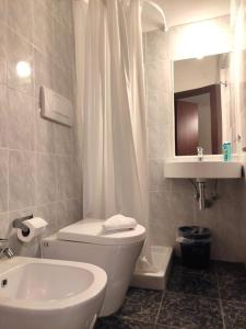 bagno con servizi igienici bianchi e lavandino di Hotel Milazzo Roma a Roma