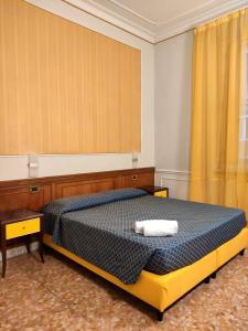 a bedroom with a bed with a blue comforter at Hotel Milazzo Roma in Rome