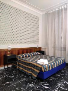 ローマにあるホテル ミラッゾ ローマの壁のある部屋のベッド1台が備わるベッドルーム1室を利用します。