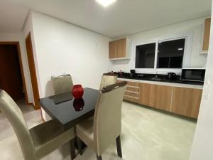 a kitchen with a table and chairs and a counter at Aptos Weber in Gramado