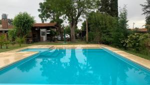 una grande piscina blu accanto a una casa di Altos de Empalme a Lobos