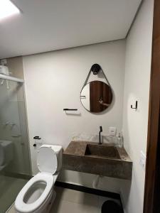 uma casa de banho com um lavatório, um WC e um espelho. em Chalé Lírio do Campo em Ouro Preto