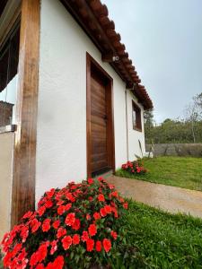 a bunch of red flowers in front of a house at Chalé Lírio do Campo in Ouro Preto