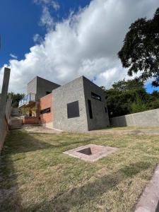 a building that is sitting in the grass at Casa da Pedra Ibitipoca in Lima Duarte